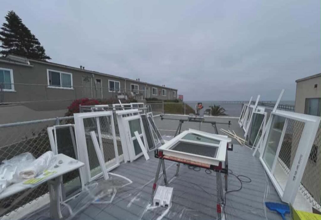 Multiple replacement windows staged for installation at a coastal San Diego apartment complex