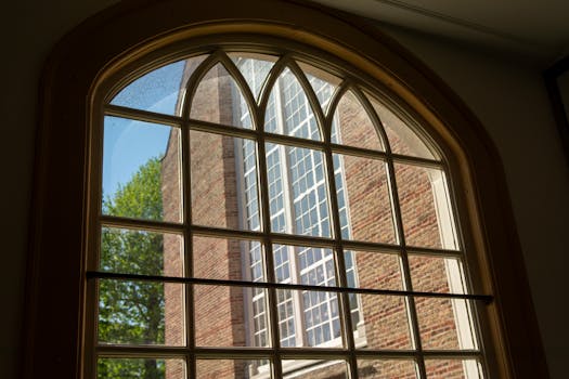 A beautiful brick church seen through an arched window, depicting serenity and architectural elegance.
